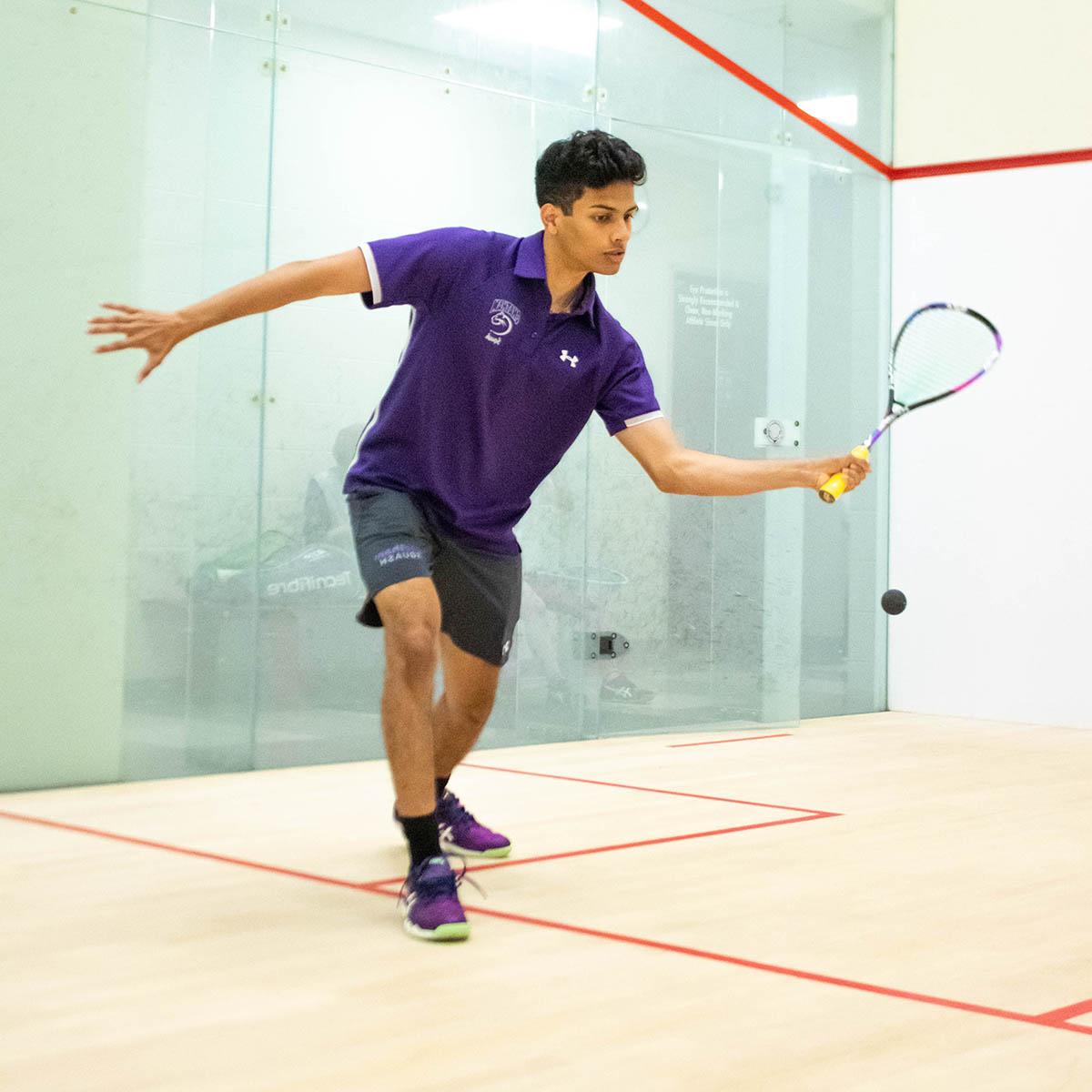 Photo of Jared playing squash in a purple Chatham uniform